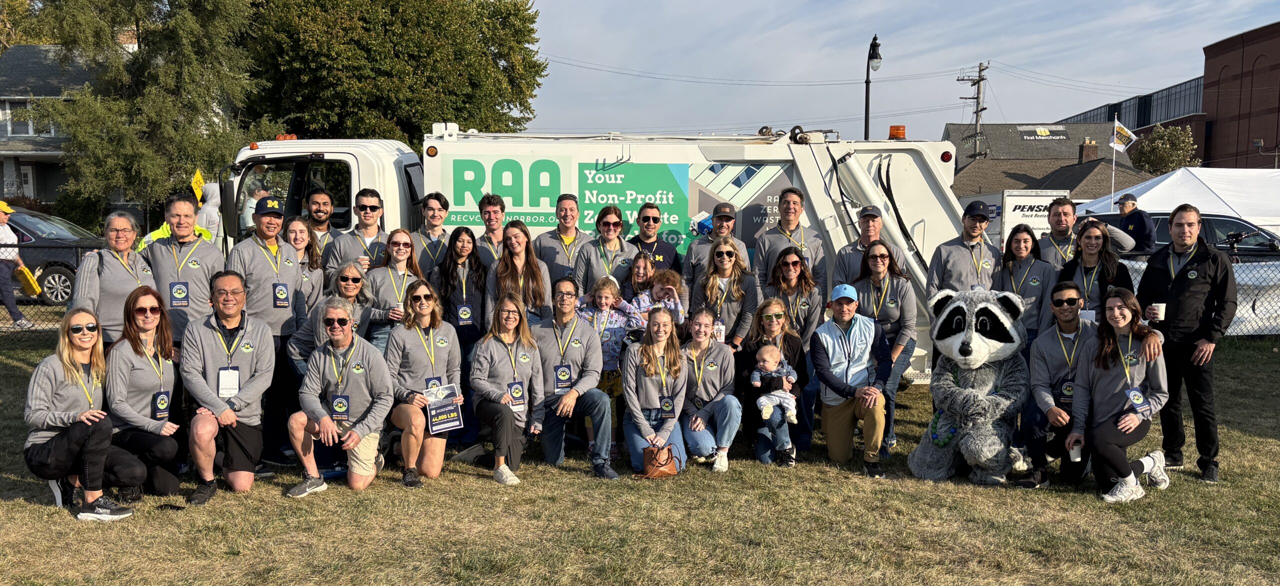Recycle Bowl volunteers, partners, and the event mascot gather for a group photo before the University of Michigan's annual game-day recycling event, which promotes PET bottle recycling and sustainability.
